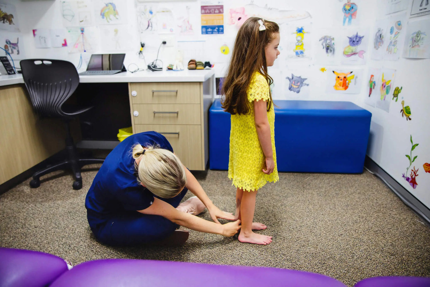 Lady measuring girl's legs